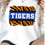 a woman wearing a white shirt with the word tigers on it